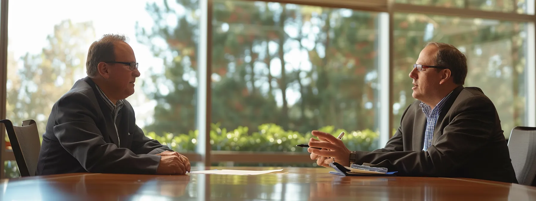 a professional consultant sitting with a business owner at a sleek conference table, discussing data infrastructure and it systems.